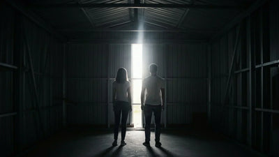 Man and woman standing inside a steel structure room looking out