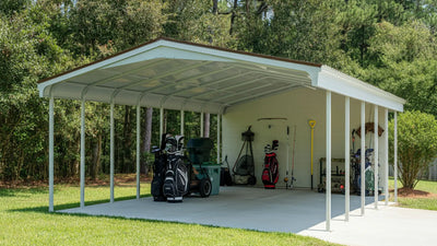Side view of a steel prefab garage storing a riding mower and garden tools