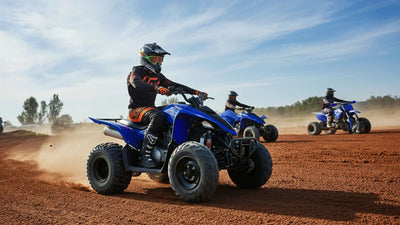 An individual riding a four-wheeler on a dirt racetrack.