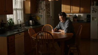 A man working on his budget and finances at his kitchen table.