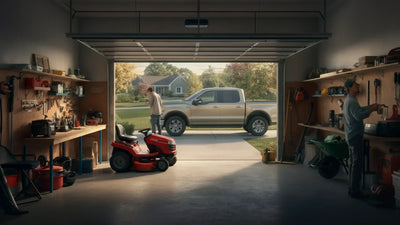 A suburban garage with a tool bench and yard tools, without enough room for a car to park in the garage.