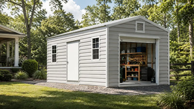 Upgraded steel backyard storage building with loft storage, shelving, and a workbench visible through the open roll-up door.